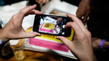 Jemand fotografiert einen gelb-pinken Kuchen, auf dem "Fight for your digital rights!" steht.